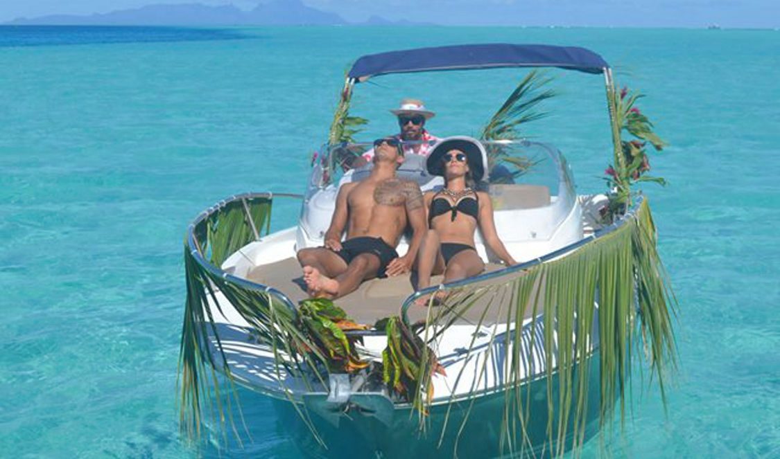 private boat tour couple relaxing over bora bora lagoon during their vacation